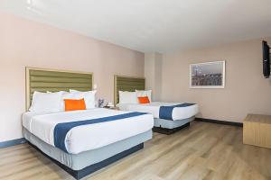 a hotel room with two beds and a tv at Pasadena Inn at Old Town, Los Angeles in Pasadena +17 photos