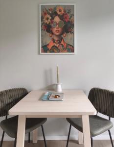 a table with two chairs and a painting on the wall at Boterbloem Bed en Brood in Hardenberg