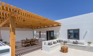 an outdoor patio with a wooden pergola at Serenya Hotel Milos in Adamantas