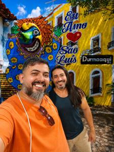 two men are standing in front of a building at durmaaquislz2 in São Luís