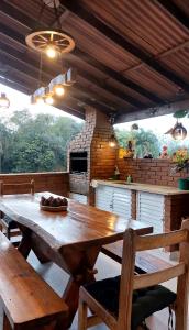 a dining room with a wooden table and chairs at Chale Recanto do Lago in Itu