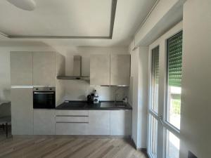 a kitchen with white cabinets and a large window at Cantalupo30 in Cantalupo