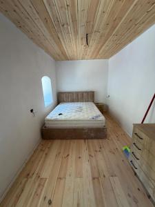 a bedroom with a bed and a wooden ceiling at Kulla e Xhem Gjokes 