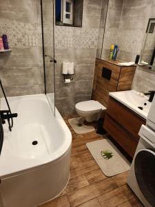 a bathroom with a tub and a toilet and a sink at Apartmán Forst in Nová Lesná +13 photos