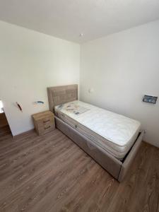 a bedroom with a bed and a wooden floor at Kulla e Xhem Gjokes 