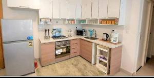 a small kitchen with a refrigerator and a stove at Chalet Marina 2 Marassi in El Alamein