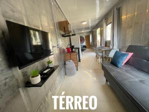 a living room with a couch and a flat screen tv at Estudio Praia do Estaleiro - Balneário Camboriú in Balneário Camboriú