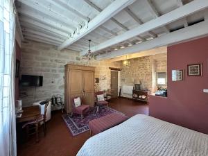 a bedroom with a bed and a desk in a room at Le trente trois in Uzès