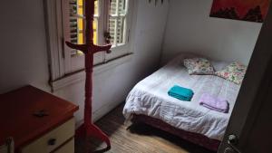 a small bedroom with a bed and a window at Casa Pugliese in Buenos Aires