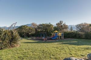 a park with a playground in the grass at Handy Location, Ocean & Mountain Views, Close to Park - KK96845 in Kaikoura