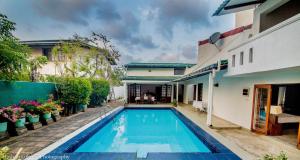 a swimming pool in front of a house at Serendipity Lake Villa in Panadura