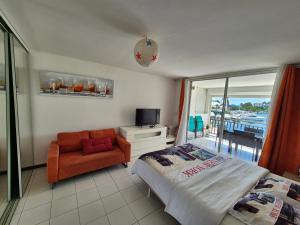 a bedroom with a bed and a chair and a balcony at Joli Studio Vue Sur Mer in Pointe-à-Pitre