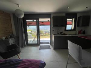 a kitchen with a open door to a patio at Au Chant des Grillons - studio ensoleillé en Gruyère in Estavannens-Dessous +52 photos