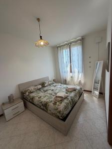 a bedroom with a bed and a dresser and a window at Ambra House in Piacenza