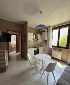 a kitchen and living room with a table and chairs at Ambra House in Piacenza