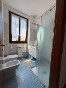 a bathroom with a shower and a toilet and a sink at Ambra House in Piacenza +11 photos