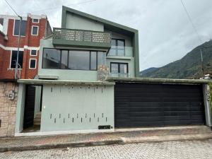 a house with a gate and a garage at Volcán Suits in Baños +6 photos