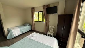 a small bedroom with two beds and a window at Volcán Suits in Baños