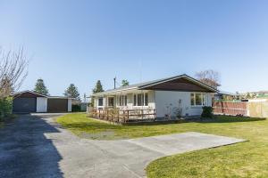 a small white house with a driveway at Central, Affordable, Boat Parking - KK18865 in Kaikoura