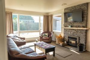 a living room with a couch and a fireplace at Central, Affordable, Boat Parking - KK18865 in Kaikoura