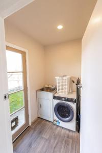 a washing machine in a laundry room with a window at Central, Affordable, Boat Parking - KK18865 in Kaikoura
