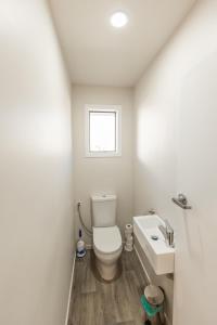 a white bathroom with a toilet and a sink at Central, Affordable, Boat Parking - KK18865 in Kaikoura +11 photos