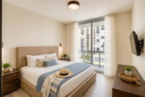 a bedroom with a bed and a large window at CH Luxury Condos & Studios On The Beach in Hollywood