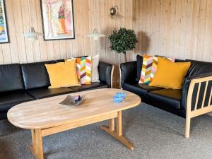 a living room with a couch and a coffee table at 4 star holiday home in Tarm in Tarm +24 photos
