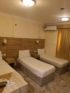 a hotel room with two beds and a desk at فندق نسك الفضيلة in Ajyad