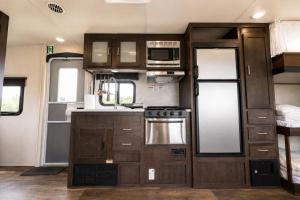 an rv kitchen with wooden cabinets and a stove at NaturalfarmZAMPA in Yomitan