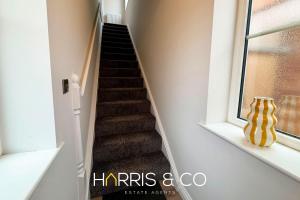 a staircase with a yellow vase sitting next to a window at Upper Marsh Apartment in Thornton +18 photos