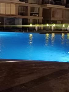 a large swimming pool with blue water at night at Chalet Marina 2 Marassi in El Alamein