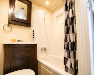 a bathroom with a toilet and a tub and a sink at NaturalfarmZAMPA in Yomitan +19 photos