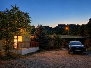 a car parked in a driveway in front of a house at Hidden Hills Cottage Sarajevo in Sarajevo