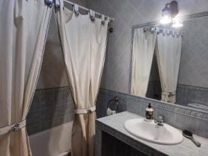 a bathroom with a sink and a shower curtain at Casa Flor de Rello in Rello