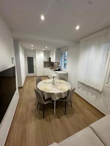 a living room with a table and chairs and a kitchen at O LAR DE DON BASILIO in Redondela
