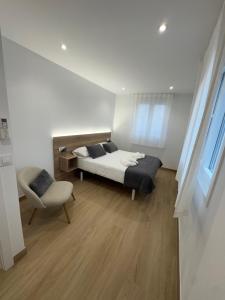 a bedroom with a bed and a chair at O LAR DE DON BASILIO in Redondela