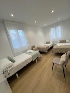 a hospital room with three beds and a chair at O LAR DE DON BASILIO in Redondela