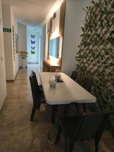 a dining room with a white table and chairs at Hospedaje Rey De Los Vientos in Yotoco