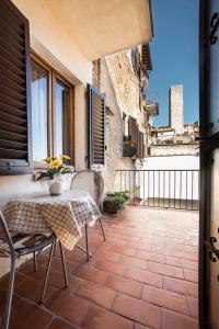 patio con mesa y sillas en el balcón en Affittacamere Chiti Melania, en San Gimignano