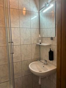 a bathroom with a sink and a shower with a mirror at Noclegi Flauta in Mielno +81 photos
