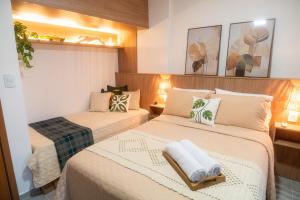 two beds in a small room with two towels at Aurora Studio no Centro in Barbacena +17 photos