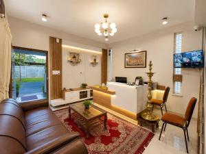 a living room with a couch and a table at Sai Grand Villas & Hotel Near Bengaluru Airport in Bangalore