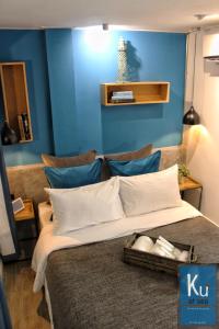 un grande letto in una stanza con una parete blu di Ku at sea a Ko Samed