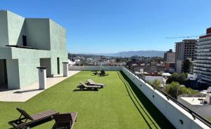 a rooftop with green grass and benches on a building at Paseo Cibeles departamento in Villa Carlos Paz