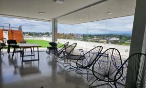a room with chairs and a table and a large window at Paseo Cibeles departamento in Villa Carlos Paz