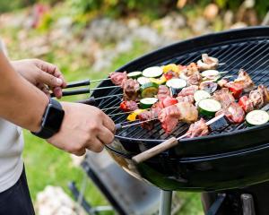 a person grilling meat and vegetables on a grill at NaturalfarmZAMPA in Yomitan