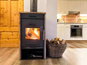 a stove with a fire in a kitchen with a basket at Sauna Chalet Ahorn in Bad Kleinkirchheim