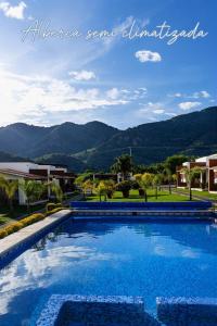 a large swimming pool with mountains in the background at Un pequeño paraíso en Malinalco in Malinalco