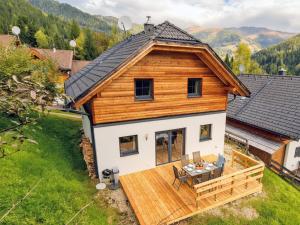 a log home with a deck and a house at Sauna Chalet Ahorn in Bad Kleinkirchheim